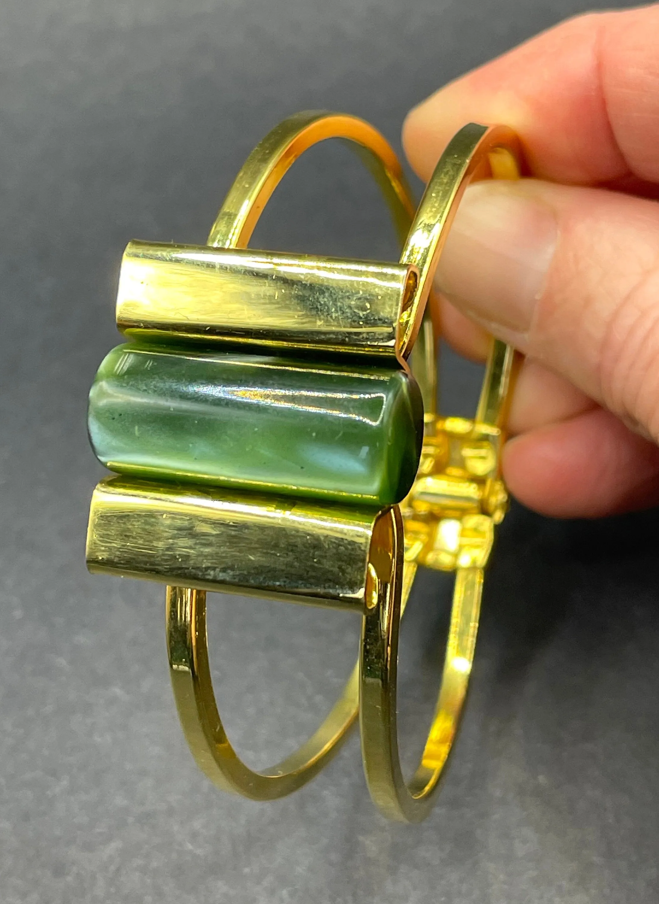 Vintage Jakob Bengel Art Deco machine age clamper bangle in shiny gold tone with a rich green galalith cylinder